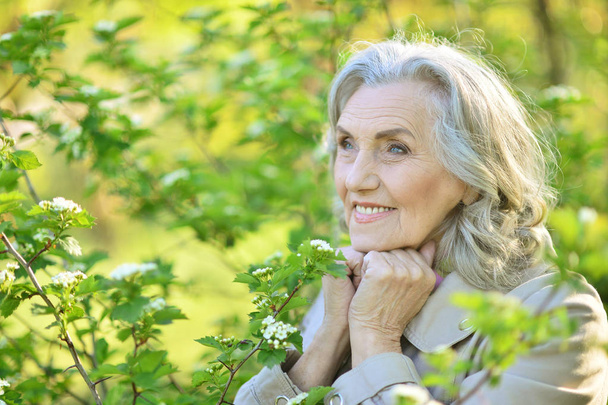 senior woman near blooming tree - Foto, Bild