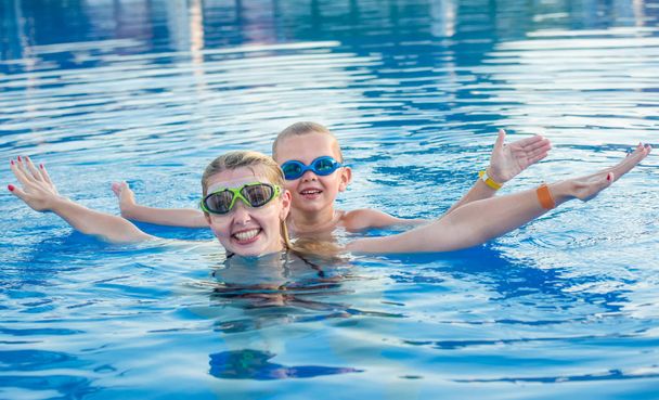 Matka i syn w Okulary pływackie popływać w basenie. Rodzinne wakacje. - Zdjęcie, obraz
