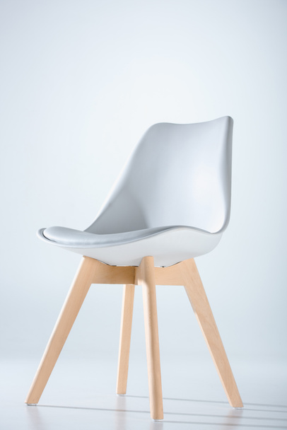 silla con tapa blanca y patas de madera
 - Foto, imagen