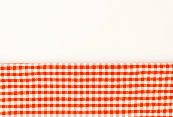 Πορτοκαλί πανί, μια πετσέτα κουζίνας με ένα μοτίβο σκακιέρας, για ένα whi - Φωτογραφία, εικόνα