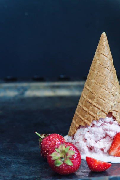Strawberry ice cream in a waffle cone inverted and melted agains - Fotografie, Obrázek