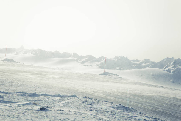 eine wunderschöne Landschaft mit einer weißen, verschneiten Straße mit Sicherheitsstangen im norwegischen Winter - Foto, Bild