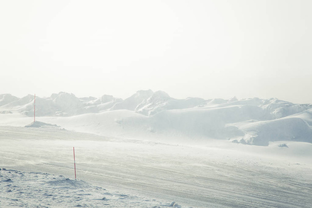 eine wunderschöne Landschaft mit einer weißen, verschneiten Straße mit Sicherheitsstangen im norwegischen Winter - Foto, Bild