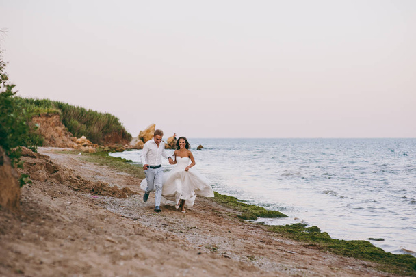 Beautiful wedding couple on a walk by the sea - Fotó, kép