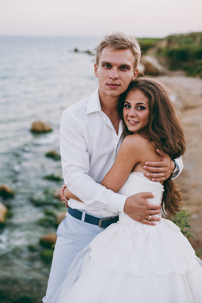 Beautiful wedding couple on a walk by the sea - Foto, afbeelding