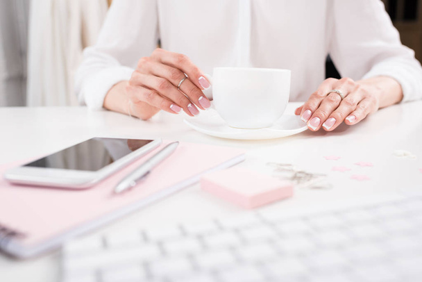 Mujer bebiendo café en el lugar de trabajo
  - Foto, Imagen