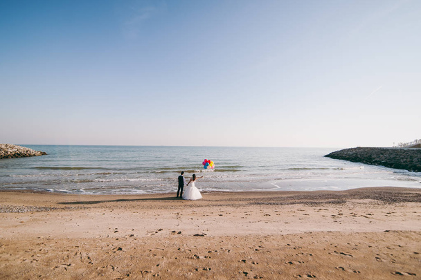 Svatební pár s míčky, procházky po pobřeží - Fotografie, Obrázek