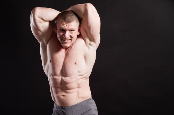 the athlete bodybuilder shows his muscles after sports - Photo, Image