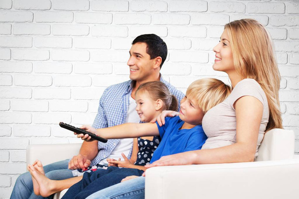 Hermosa familia encantadora viendo la televisión
  - Foto, imagen