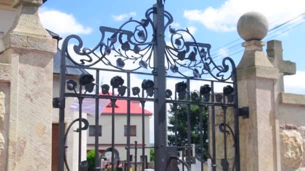 View of cemetery, graveyard , churchyard, burial ground through forged gate. - Footage, Video