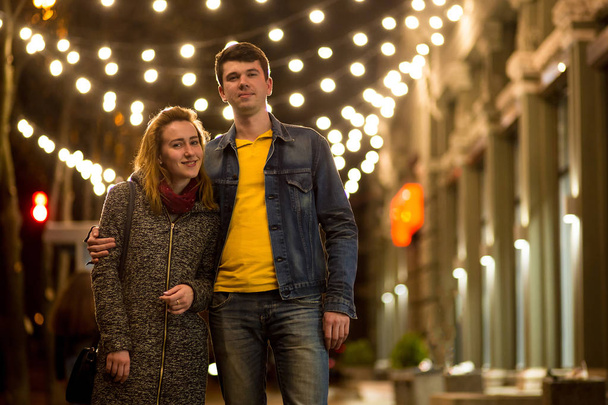 Outdoor portrait of young beautiful happy smiling couple posing on street. - Photo, image