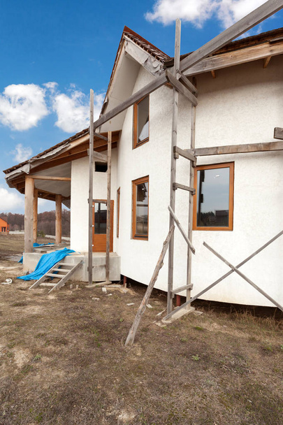 Construcción de casa de adobe con techo de paja y ventanas de plástico
 . - Foto, Imagen