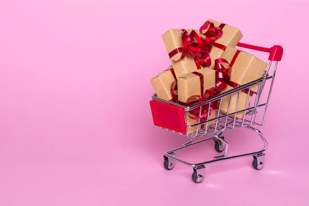 Concetto creativo con carrello della spesa con regali su sfondo rosa
. - Foto, immagini