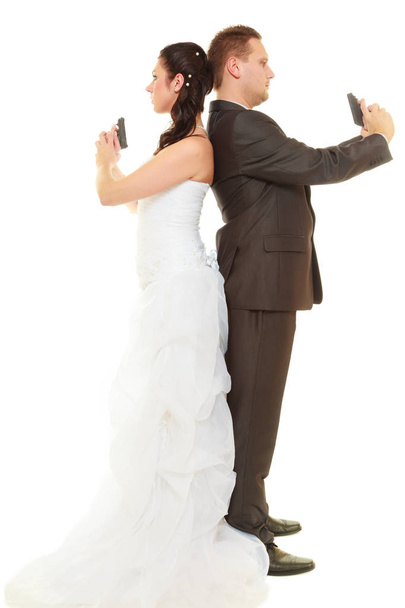 Marié et marié en tenue de mariage tenant des armes
 - Photo, image