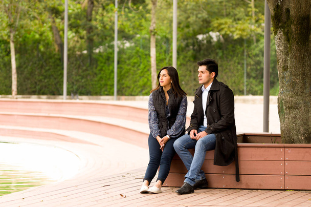 Beautiful young couple in love in st valentines day sitting in a park - Foto, imagen