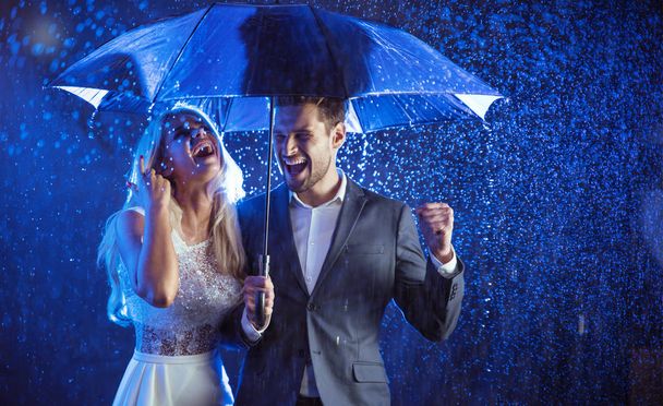 Cheerful couple enjoying the summer rain - Foto, immagini