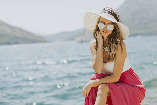 Joven mujer atractiva posa junto al mar
 - Foto, imagen