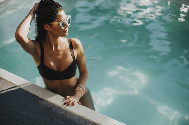 Csinos, fiatal nő relaxcing, a medence mellett - Fotó, kép