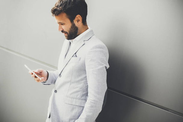 Young businessman using phone in office - Foto, Bild