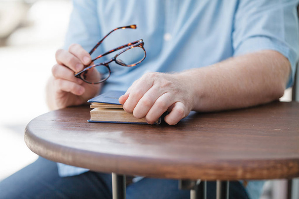 handsome young businessman in casual clothes and eyeglasses reading a book - Foto, immagini