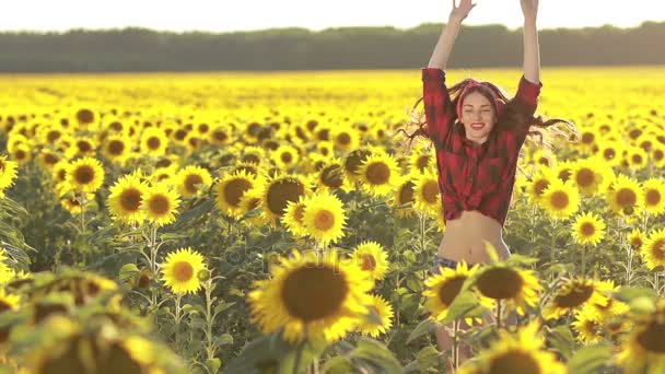 Emotionaalinen viehättävä tyttö hyppääminen auringonkukkakentällä
 - Materiaali, video