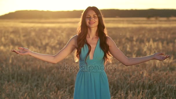Красива брюнетка в пшеничному полі на заході сонця
 - Кадри, відео