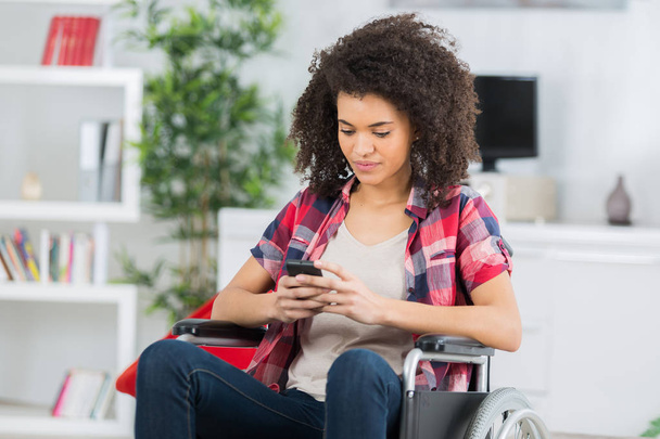 disabled woman in wheelchair on mobile phone - Foto, imagen