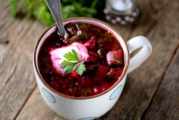 Traditional Ukrainian soup borsch on an old wooden background. Rustic style. - Photo, Image