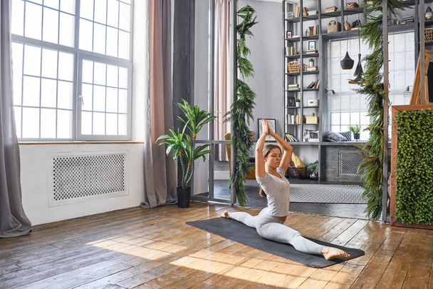 Woman practicing advanced yoga in the living room - Fotoğraf, Görsel