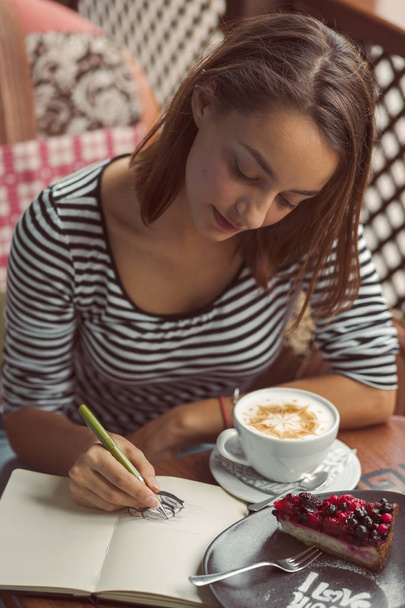 kapalı kentsel cafede oturan genç kadın - Fotoğraf, Görsel