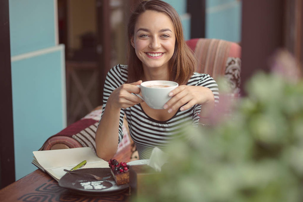 fiatal nő ül a fedett városi kávézó - Fotó, kép