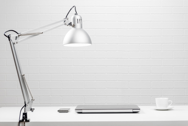 Lugar de trabajo vacío - mesa blanca y pared de ladrillo blanco
 - Foto, Imagen