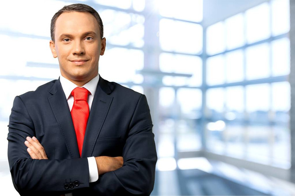 Businessman standing with arms crossed - Foto, Bild