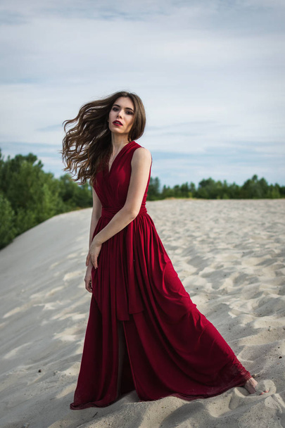 Gyönyörű lány, piros ruhában a parton. A nőiesség fogalma, harmónia - Fotó, kép