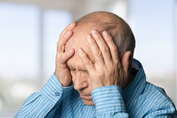 mature man holding his head in pain - Valokuva, kuva
