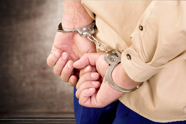 Чоловік в наручниках за спиною
 - Фото, зображення