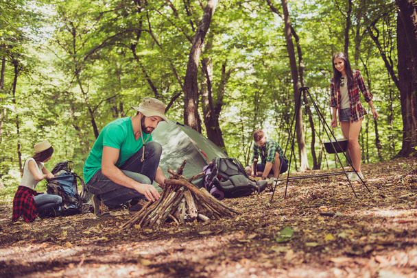 Trekking, camping and wild life concept. Four best friends are hiking in the spring woods, ladies are talking and laughing, all are excited and anxious in  jungle trail - Foto, immagini