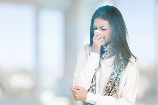  woman sneezing in a tissue  - Foto, Bild
