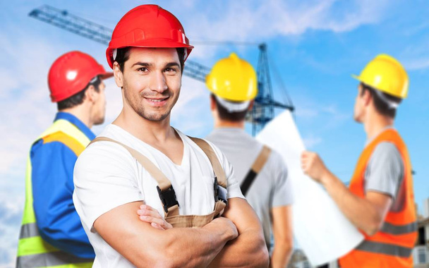 business, building, teamwork and people concept - group of smiling builders in hardhats at construction site - Foto, Imagen