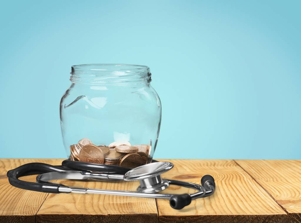 Money Jar with coins and stethoscope - Фото, зображення
