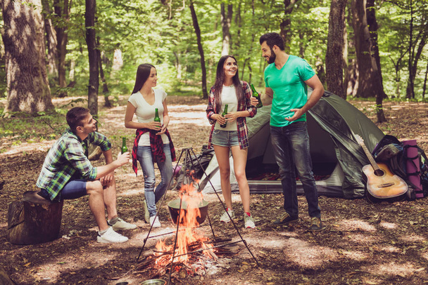 Trekking, camping and wild life concept. Four best friends are hiking in the spring woods, ladies are talking and laughing, all are excited and anxious in  jungle trail - Fotoğraf, Görsel