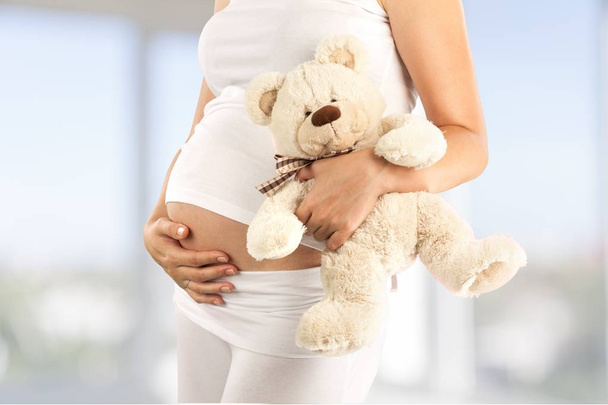 pregnant woman holding bear - Zdjęcie, obraz