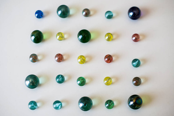 Glass marbles on a white table  - Photo, Image