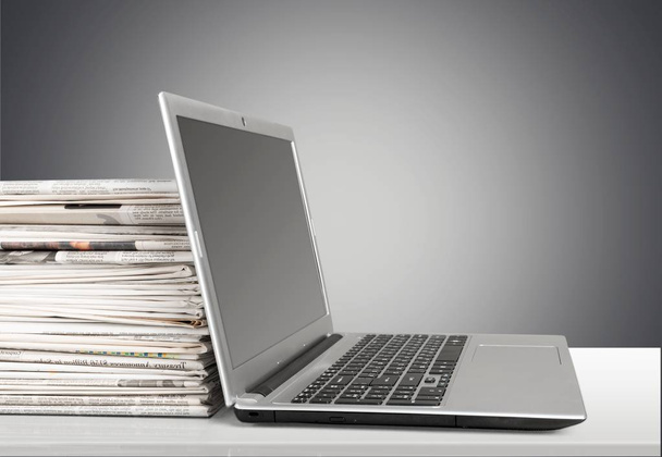 Stack of newspapers with laptop - Foto, Bild