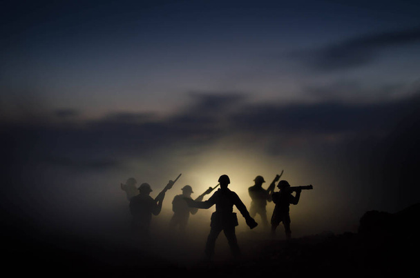 Концепция войны. Военные силуэты боевой сцены на фоне тумана на фоне неба войны, силуэты солдат мировой войны под облачным горизонтом ночью. Сцена нападения. Бронетехника. Танки
 - Фото, изображение