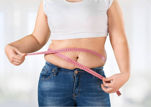 fat woman measuring her stomach - Foto, immagini