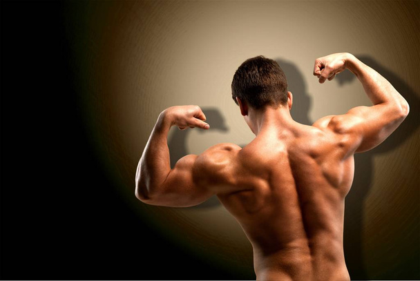 Bodybuilder showing his muscles - 写真・画像