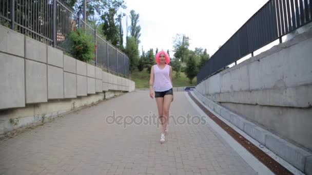 Steadicam tiro de raça mista moderno hipster adolescente menina andando vestindo peruca rosa
 - Filmagem, Vídeo