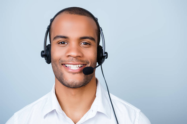 Young cheerful african guy call center worker in headset on a pu - Zdjęcie, obraz