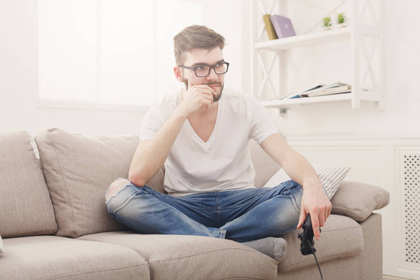 Disappointed young man at home playing video games and loses - Photo, image